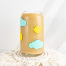 Load image into Gallery viewer, Yellow suns and mint clouds are on this 16 oz can shaped glass cup. It is filled with coffee on a coaster. 
