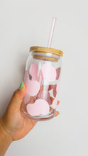 Load image into Gallery viewer, pink Cow Prin beer glass shaped can with a lid and a light pink straw being held against a white backdrop.
