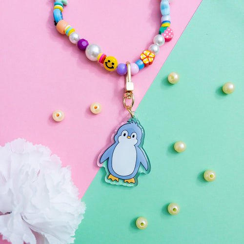 This is a cute penguin Keychain with a gold polished swivel clasp on a plain pink background