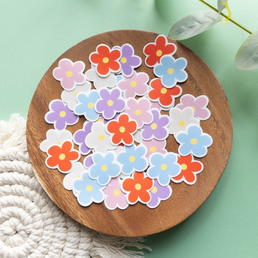 Colorful flowers: Orange, pink , blue , purple and white flowers are laid out on a wooden plate. 